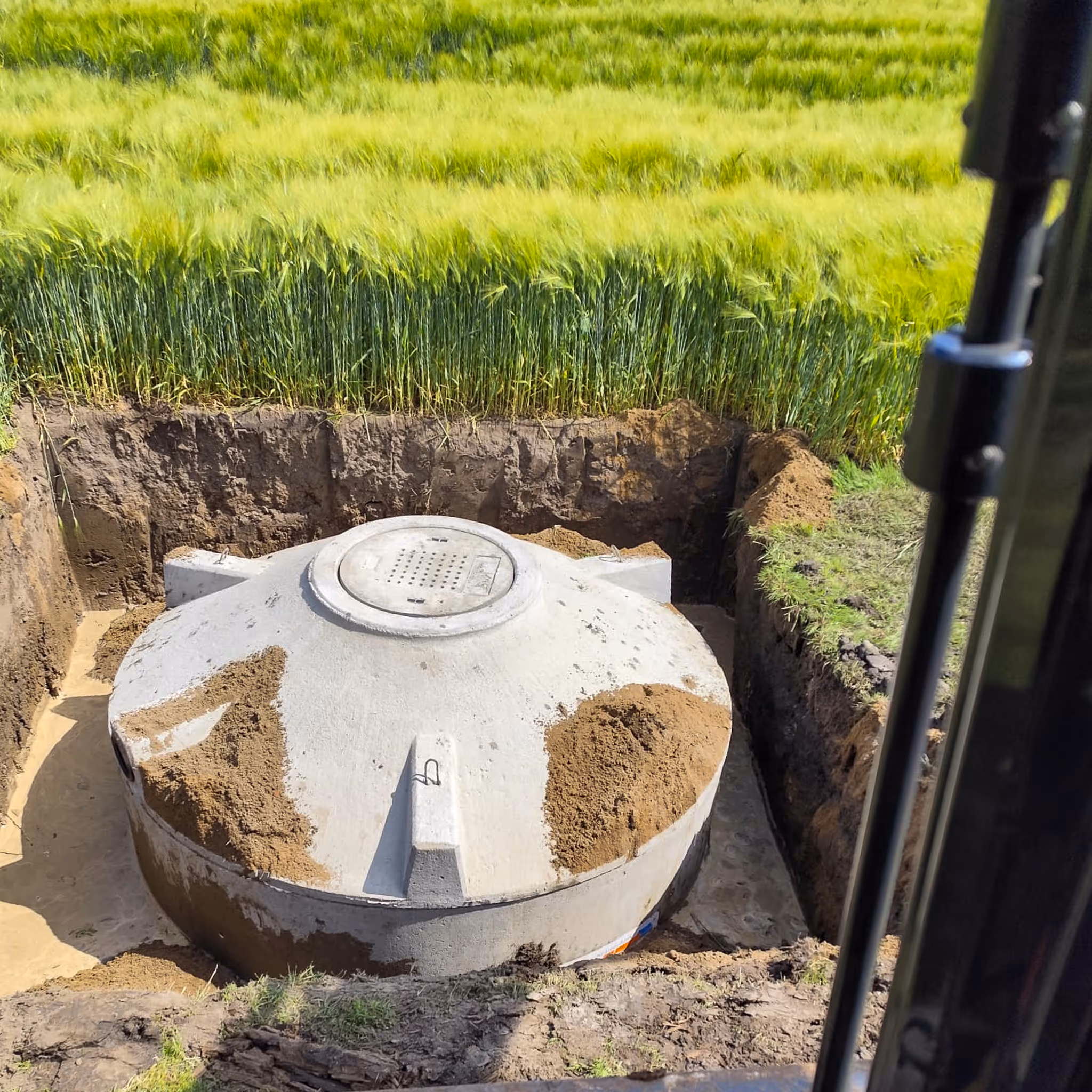 Kläranlagenbehälter in der Baugrube am Feldrand