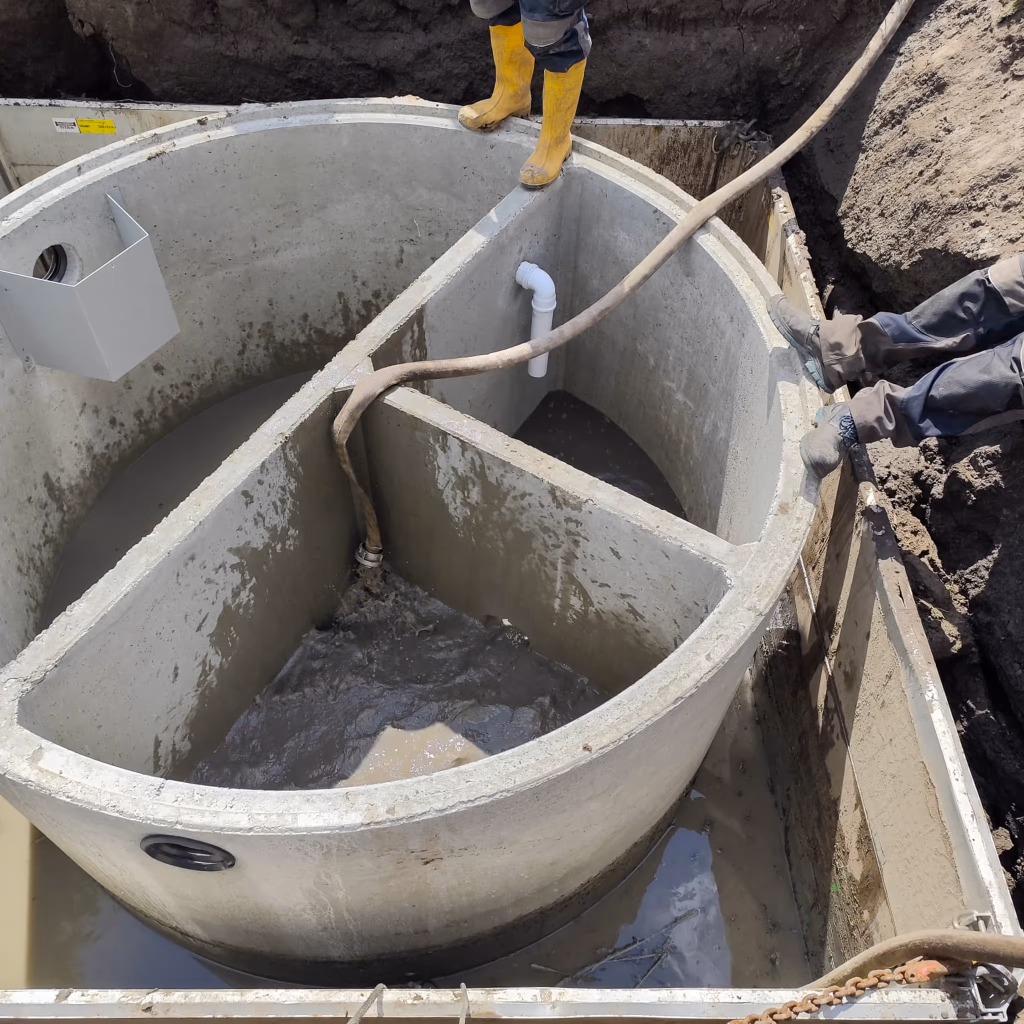Mehrkammergrube aus Beton beim Einbau mit Trennwänden und Rohranschlüssen