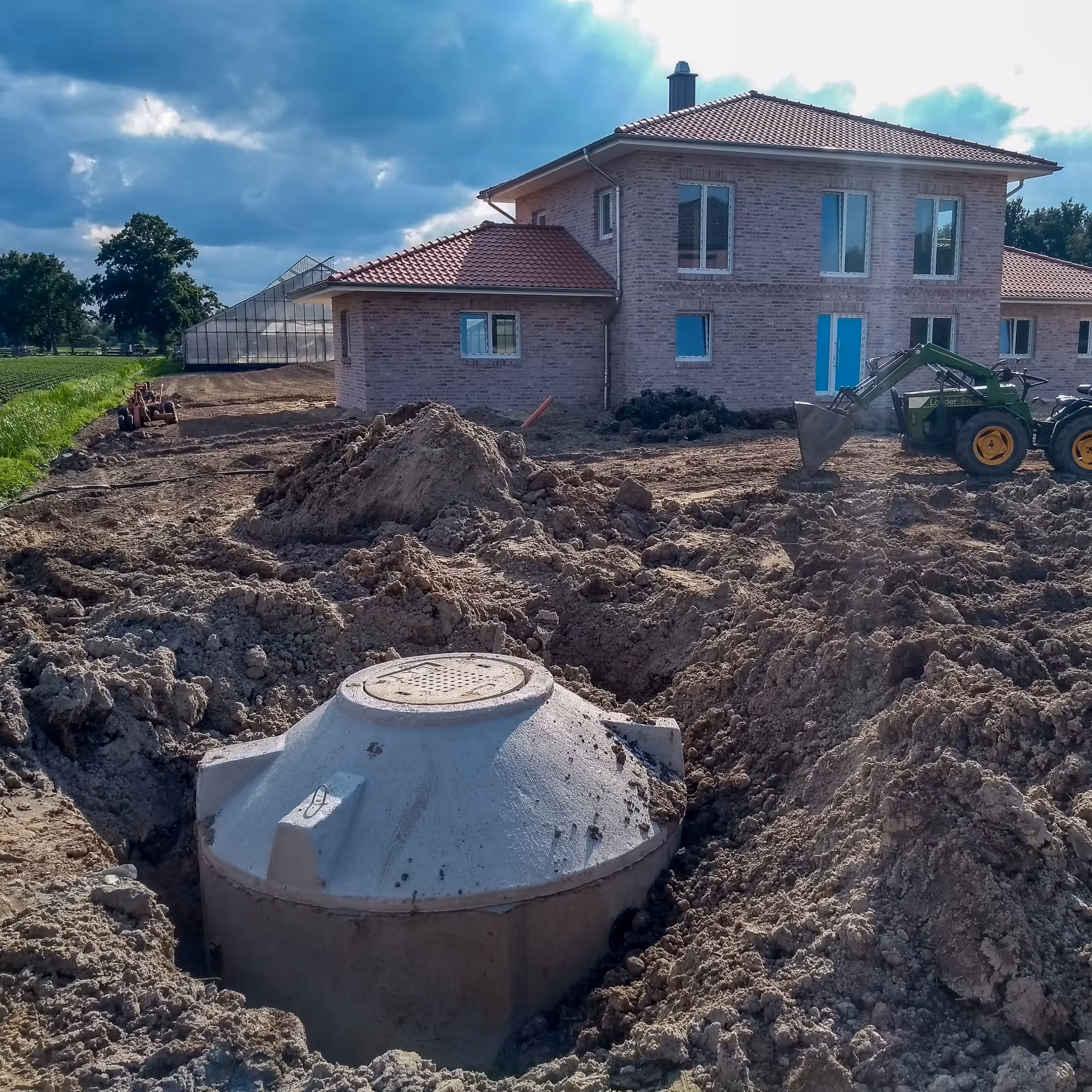 Behälter einer Kleinkläranlage in der Baugrube vor einem Einfamilienhaus
