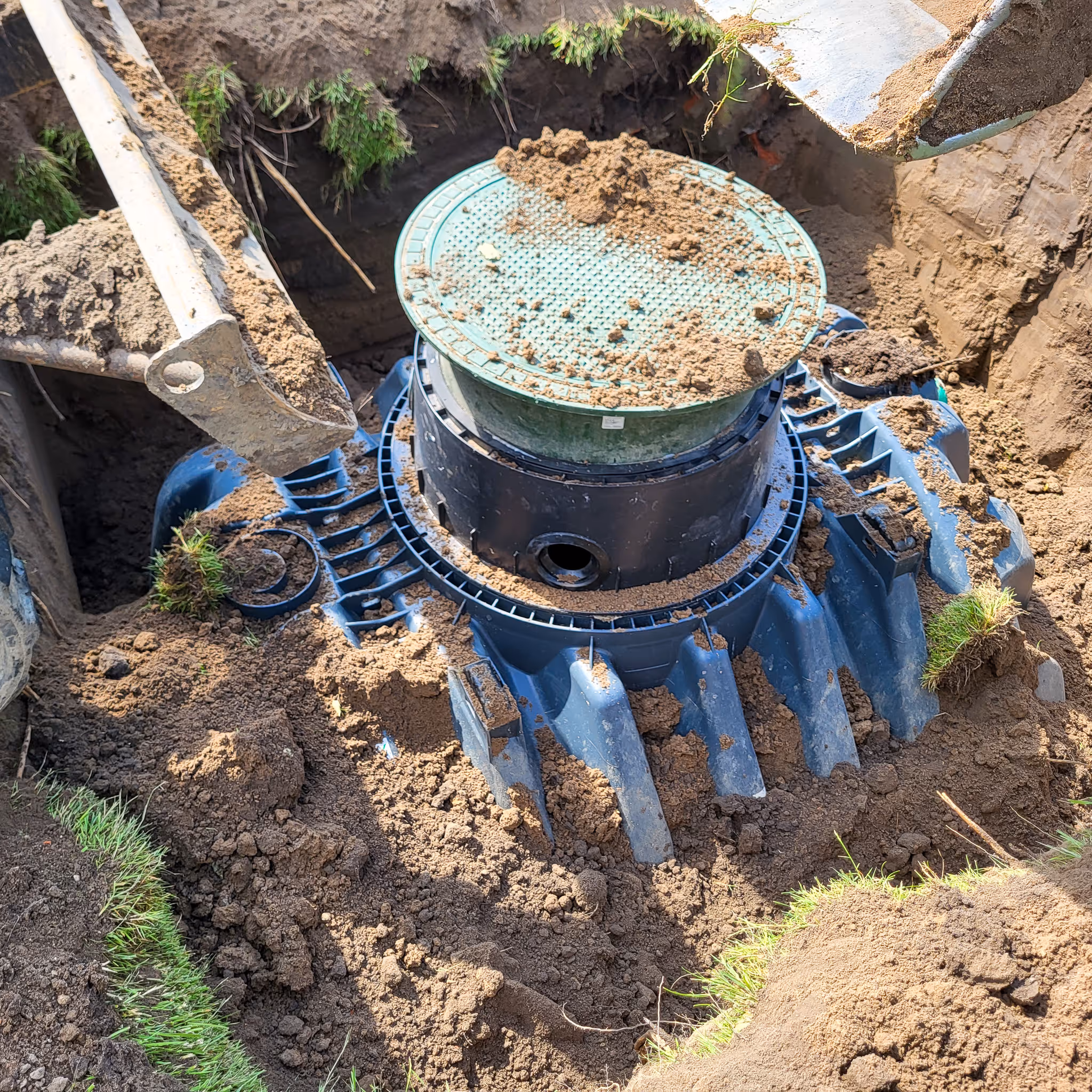 Kunststoff-Kleinkläranlage mit Domschacht beim Einbau im Erdreich